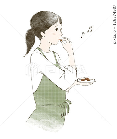 家事の合間にお菓子をつまむエプロン姿の女性 126574987