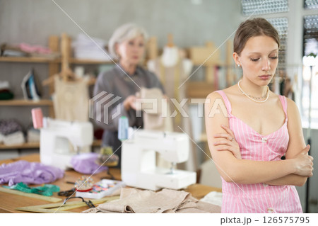 Mature dressmaker scolds assistant at work 126575795
