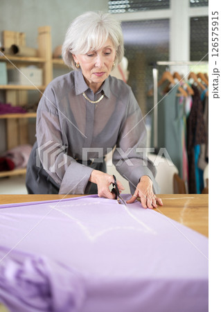 Woman seamstress cutting fabric in sewing workshop 126575915