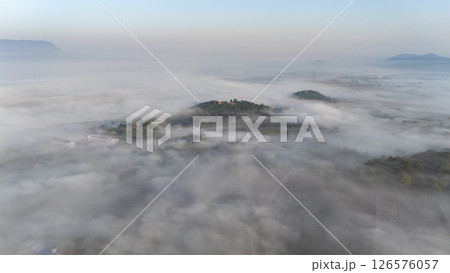 Aerial view of fog covered small hills in Pa Daet district one of the southern part of Chiang Rai province of Thailand during winter season. Aerial view of fog covered small hills in Pa Daet district one of the southern part of Chiang Rai province of Thailand during winter season. 126576057