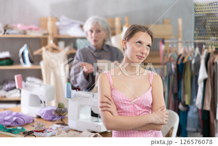 Mature dressmaker scolds assistant at work Mature dressmaker scolds assistant at work 126576078