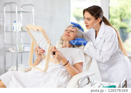 Mature patient with mirror, doctor with gloves 126576169