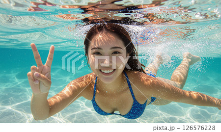青いビキニでピースサインをしながら水中を泳ぐ日本人女性 青いビキニでピースサインをしながら水中を泳ぐ日本人女性 126576228