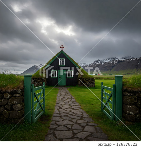 Historic black turf roof church with a green door in a rural Icelandic landscape 126576522