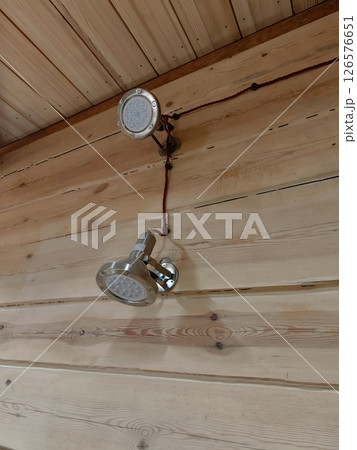 modern ceiling lights installed on natural wood paneling in cozy indoor setting. closeup. 126576651