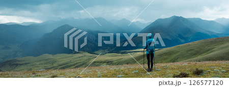 Woman backpacker hiking on high altitude mountain top after the rain Woman backpacker hiking on high altitude mountain top after the rain 126577120