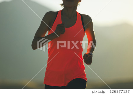 Fitness woman runner running at sunset mountain top Fitness woman runner running at sunset mountain top 126577127