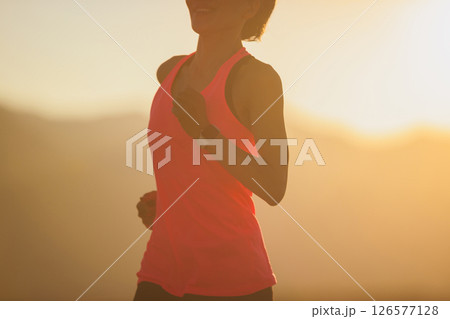 Fitness woman runner running at sunset mountain top 126577128