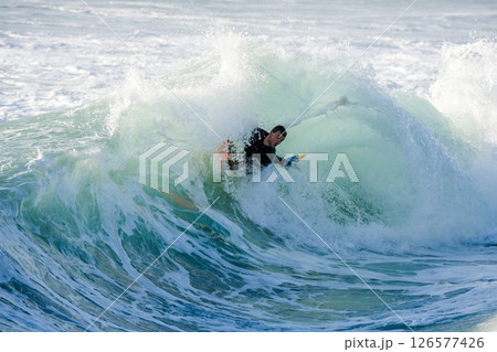Bodyboarder surfing ocean wave 126577426