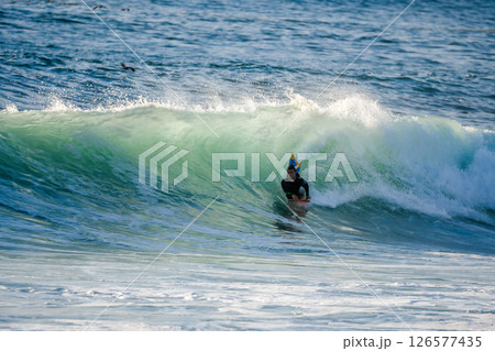 Bodyboarder surfing ocean wave 126577435