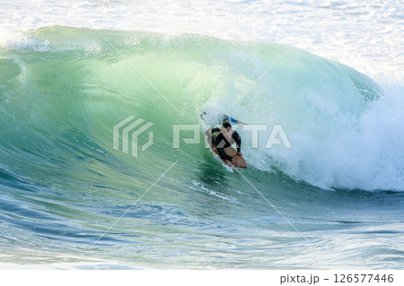 Bodyboarder surfing ocean wave 126577446