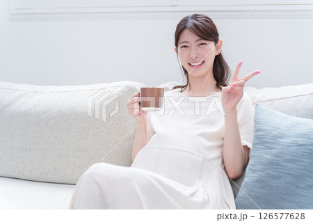 マグカップで飲み物を飲む妊婦 マグカップで飲み物を飲む妊婦 126577628
