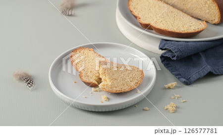 Slices of traditional Portuguese Easter folar on white plates with delicate feathers Slices of traditional Portuguese Easter folar on white plates with delicate feathers 126577781