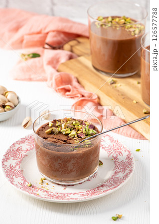 Delicious chocolate mousse topped with pistachios in glasses Delicious chocolate mousse topped with pistachios in glasses 126577788