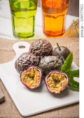 Passion fruits on white ceramic tray on wooden table background. Passion fruits on white ceramic tray on wooden table background. 126577921
