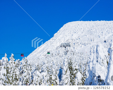 ロープウェイの背後にそびえる樹氷に覆われた三宝荒神山 (山形県、蔵王温泉スキー場) 126578152