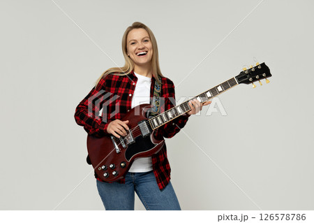 Attractive young girl playing the guitar on a white background Attractive young girl playing the guitar on a white background 126578786
