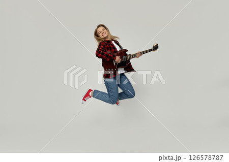 Attractive young girl playing the guitar on a white background 126578787