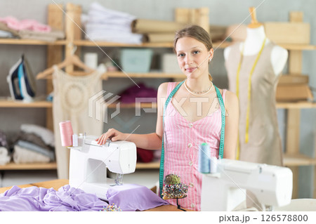 Young female dressmaker welcoming clients in sewing workshop 126578800