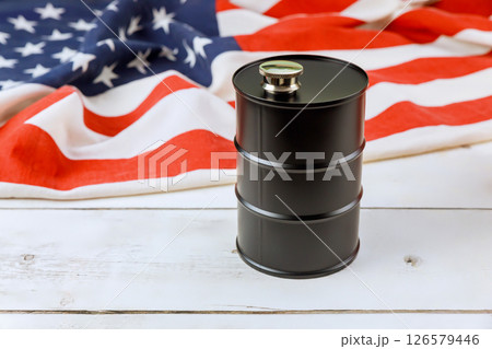 Oil barrel positioned on folded American flag, representing energy national pride Oil barrel positioned on folded American flag, representing energy national pride 126579446