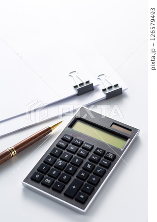 クリップで挟んだ資料と電卓 126579493