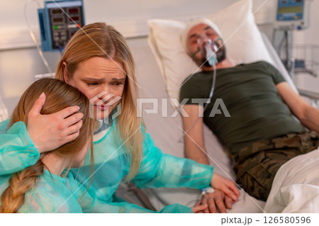 A touching hospital scene shows a family giving steadfast support to their loved one A touching hospital scene shows a family giving steadfast support to their loved one 126580596