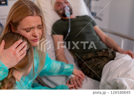 A deeply emotional family moment shared in a hospital room filled with care and affection 126580695