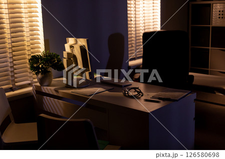 A Cozy Evening Office Scene Featuring Soft Lighting, Lush Plants, and a Welcoming Ambiance 126580698