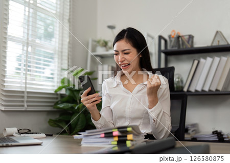Celebrating success. A businesswoman joyfully reacting to a phone call in her office. Celebrating success. A businesswoman joyfully reacting to a phone call in her office. 126580875