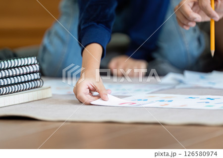 Back to School and Focused Learning. A child engages in educational activities while his father supports him. 126580974