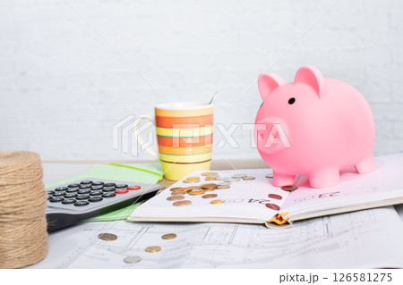 Engaging in Effective Financial Planning with a Cheerful Pink Piggy Bank and Fresh Coffee 126581275