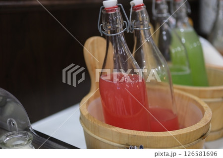 watermelon juice in bottles in the buffet detailed view of refreshing watermelon juice served in glass mugs with handles and straws. 126581696