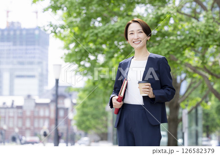 ビジネス　コーヒーカップを持ってオフィス街を歩く女性 126582379