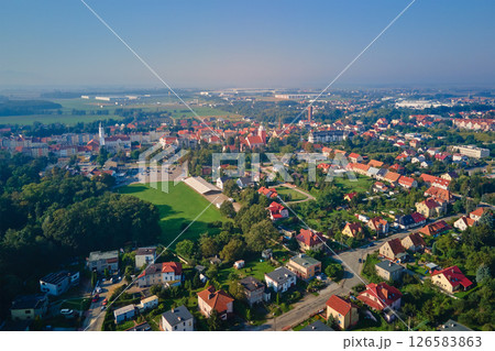Aerial view of European small town. Drone view of urban landscape with residential building, green parks and city streets Aerial view of European small town. Drone view of urban landscape with residential building, green parks and city streets 126583863