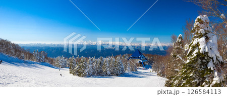 森に囲まれた閑静な広い斜面と遠くの山並みを望む (山形県、蔵王温泉スキー場、ユートピアゲレンデ) 126584113