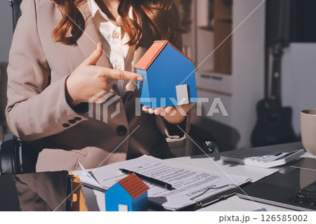 Female Real Estate Broker presenting and advised to model home and building project detail in the office, sign purchase sales contract, agreements concerned mortgage loan offer and insurance. 126585002