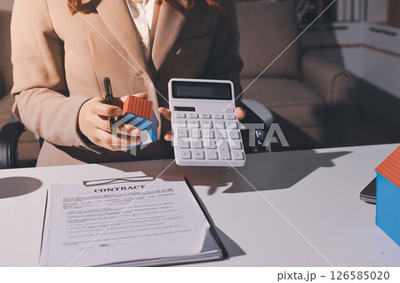 Female Real Estate Broker presenting and advised to model home and building project detail in the office, sign purchase sales contract, agreements concerned mortgage loan offer and insurance. Female Real Estate Broker presenting and advised to model home and building project detail in the office, sign purchase sales contract, agreements concerned mortgage loan offer and insurance. 126585020