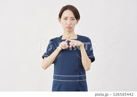 女性　美容看護師　指でバツのジェスチャー　白背景 126585442