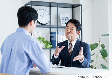 若い男性に説明するコンサルタント 126585602