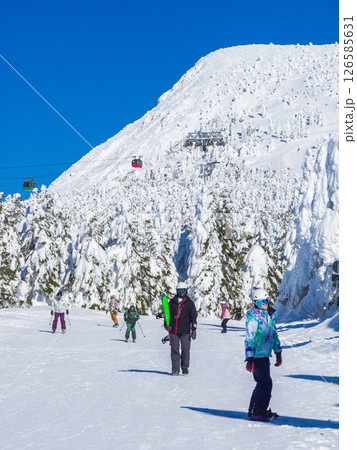 雪と樹氷に覆われた三宝荒神山と樹氷原の緩斜面を進む人々 (山形県、蔵王温泉スキー場、樹氷原コース) 雪と樹氷に覆われた三宝荒神山と樹氷原の緩斜面を進む人々 (山形県、蔵王温泉スキー場、樹氷原コース) 126585631