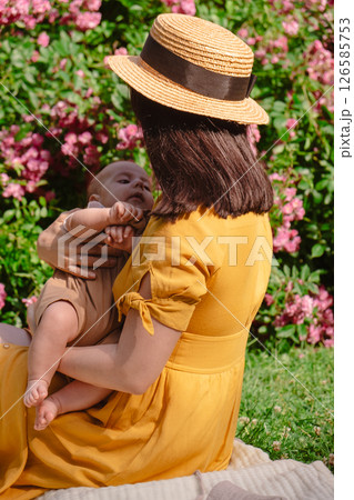 Joyful Mother and Baby in Blooming Garden 126585753