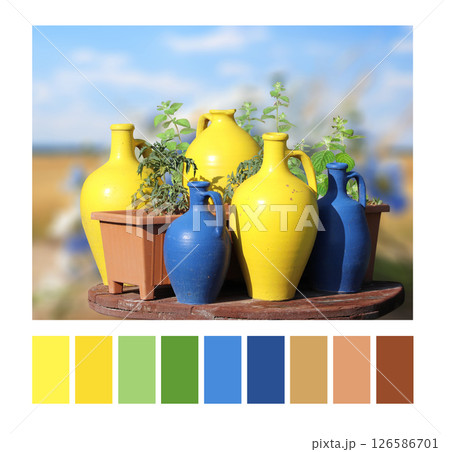 Color matching palette with complementary colour swatches. Rustic clay jug of yellow, blue colors on sunny background. Colourful jugs on blurred backdrop of countryside. Summer color matching palette Color matching palette with complementary colour swatches. Rustic clay jug of yellow, blue colors on sunny background. Colourful jugs on blurred backdrop of countryside. Summer color matching palette 126586701