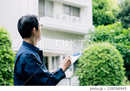 屋外で設備を点検する中高年男性 屋外で設備を点検する中高年男性 126586945