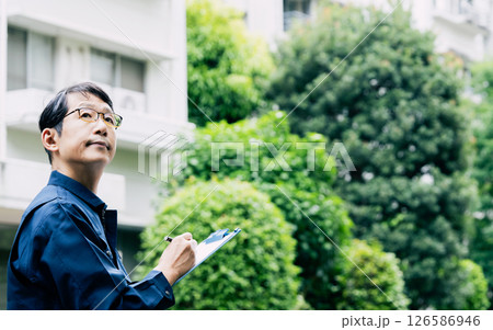 屋外で設備を点検する中高年男性 屋外で設備を点検する中高年男性 126586946