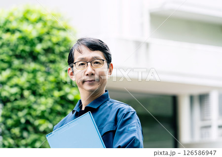 屋外で設備を点検する中高年男性 126586947