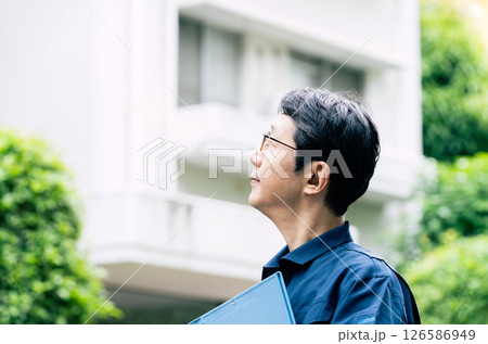 屋外で設備を点検する中高年男性 屋外で設備を点検する中高年男性 126586949