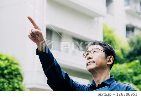 屋外で設備を点検する中高年男性 126586953
