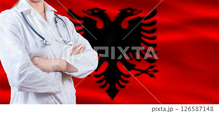 Doctor with crossed arms on Albania flag. Albania health and care concept. Female doctor on Albania flag Doctor with crossed arms on Albania flag. Albania health and care concept. Female doctor on Albania flag 126587148