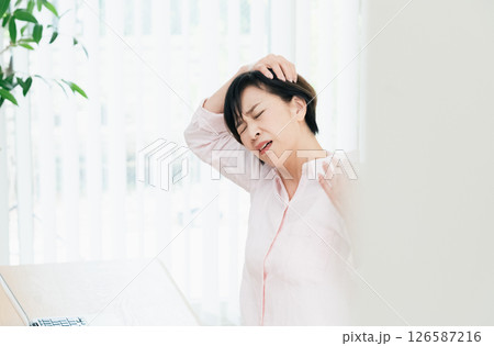 首のこりをストレッチする中高年女性 126587216