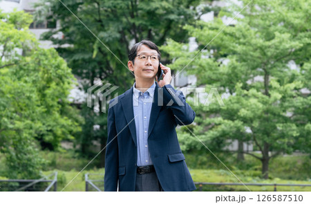屋外でスマホ通話するビジネスマン 126587510